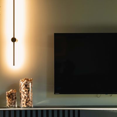 Veggarmatur, TV og glasskrukker med kork på lav benk i stue