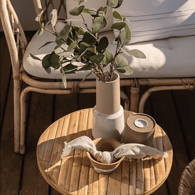Utebord på balkong med vase, eukalyptus og dukede servietter