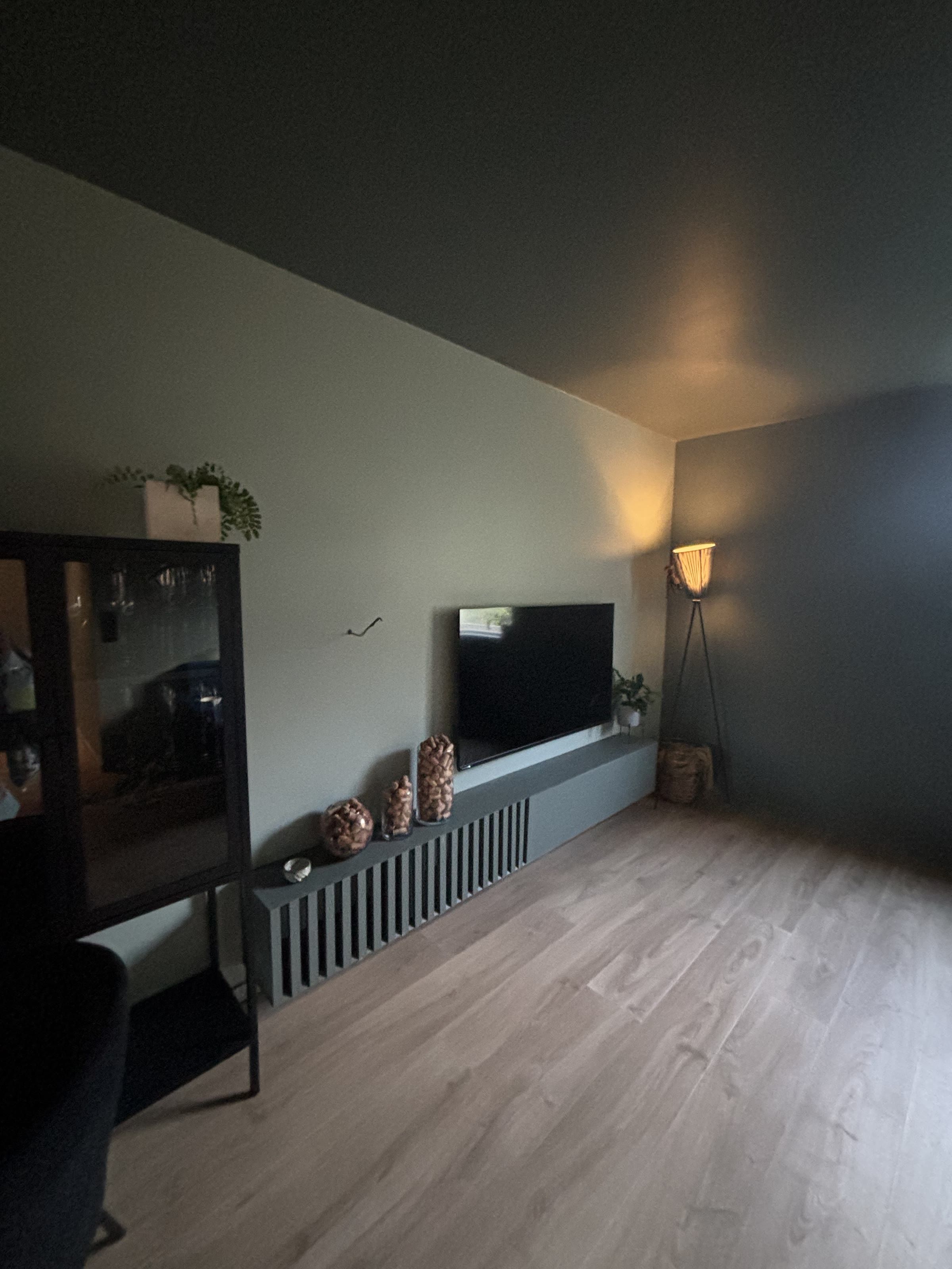 Ferdig stue med integrert TV-benk, salviegrønne vegger og lyst tregulv